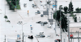 2023年6月愛知県で豪雨により梅田川が氾濫。多数の車両が冠水した道路で水没し動けなくなっている様子。